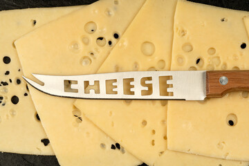 Knife with the inscription Cheese. Texture of Radomer cheese with close-up on a black background