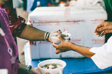 Hands of hungry people asking for free food from volunteers : humanitarian aid concept