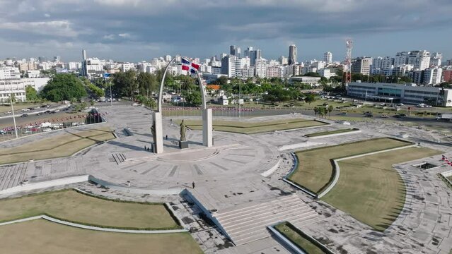 Aerial panoramic shot of traffic on roundabout of Santo Domingo City during sunlight - Memorial on Plaza de La Bandera 