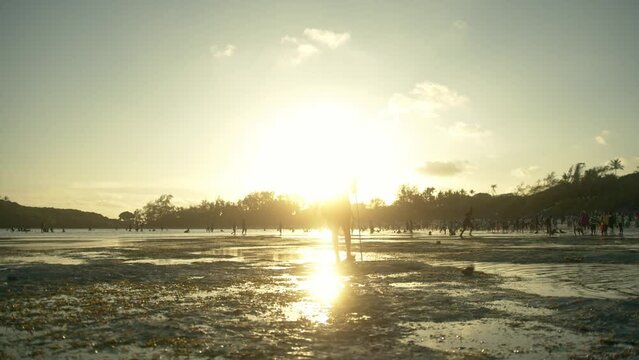 Silhouette Of Masai Warrior Walking On The Beach Backlit With Sunset In Watamu, Kenya. - wide