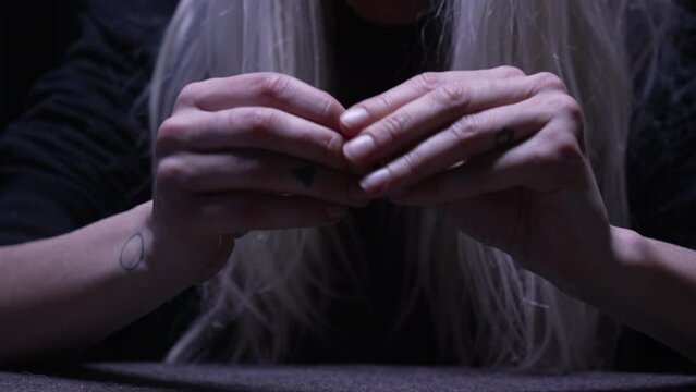Woman's hands pulling, ripping finger nails from both hands nervously unable to calm her nerves and seemingly unaware of the damage she was inflicting upon herself