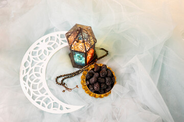 Eid Mubarak flatly image with copy space, Ramadan Kareem banner image crescent moon and lantern lamp with dates in a golden bowl