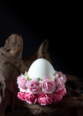 Easter egg with pink flowers on a rustic wood background.