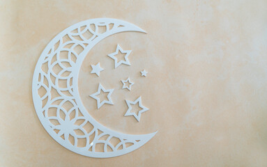 Islamic concept crescent moon and small stars isolated on beige colour background with copy space, Ramadan Kareem and Eid Mubarak greeting concept banner image