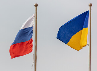 Flags of Russia and Ukraine against the sky.