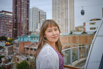 cheerful and passive white-skinned latina woman in la paz city with dress and sunset