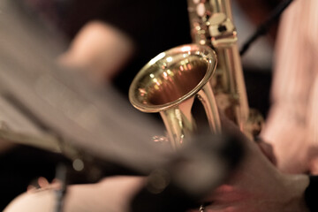 A musician holding a shiny alto saxophone