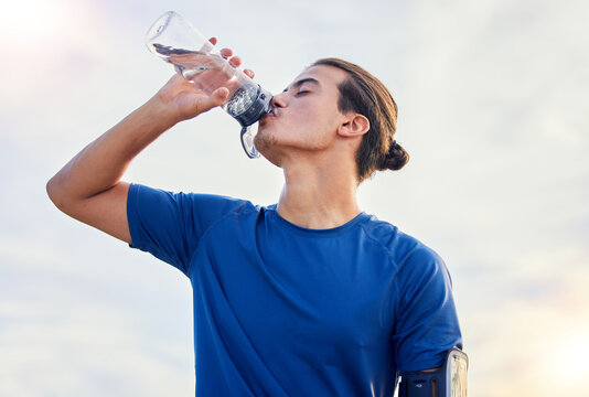 Relax, drinking water and running with man in city for health, workout and marathon training. Fitness, mindset and summer with runner jogging in outdoors for hydration, energy and exercise wellness