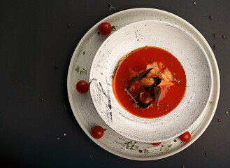 Bouillabaisse soup with shrimps, calm and fish perch on a black background