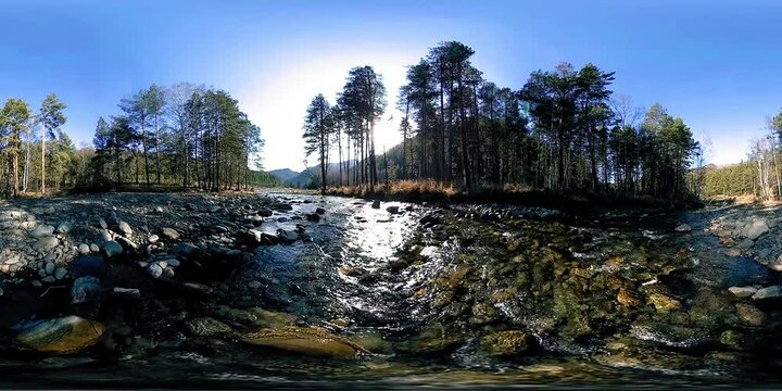 4K 360 VR virtual reality of a beautiful mountain scene at the early autumn or summer time. Wild mountains, pine forest and river flows. National park, meadow and sun rays.