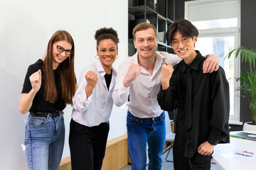 A happy multinational team rejoices at the successful start of business in the office