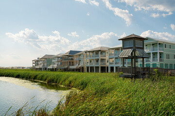 Lagoon with tall grasses near the pavilion at the front of three-storey houses in Destin, Florida....