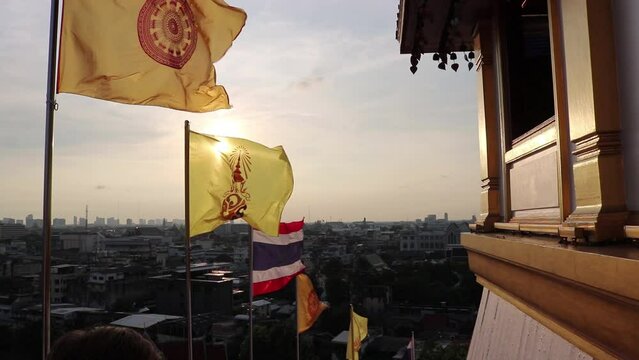 Dharmachakra  flags and National Thai flag at sunset in Bangkok, Golden Mount Temple (Wat Saket), Thailand.