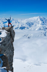 A climber standing on the cliff on Mt Denali  in Alaska, the highest mountain in North America