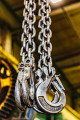 Metal industrial chains with hooks in the workshop of a metallurgical plant.