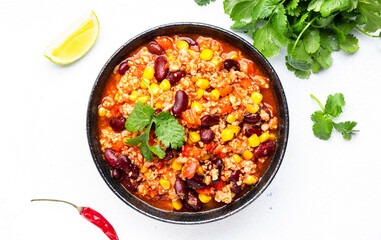 Chili con carne with beef, red beans, paprika, corn and hot peppers in tomato sauce, spicy tex-mex dish, white table background, top view