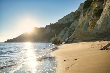 View of a Corfu beach in Greece along cliffs on a sunny day.