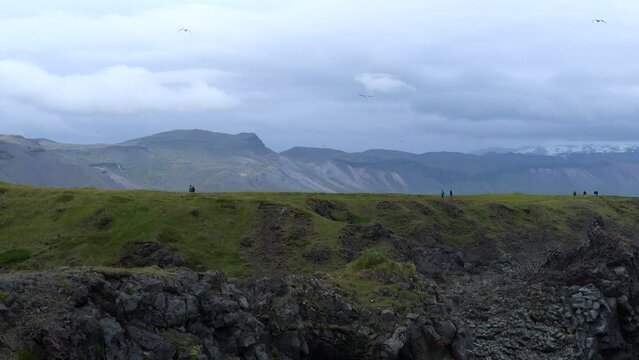 People Hiking at Arnarstapi on Peninsula Sn&aelig;fellsnes in Iceland, 4K