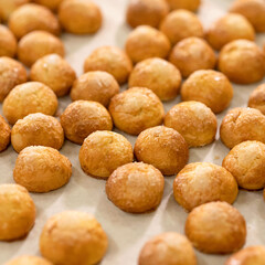 Round cookies with sugar on baking paper. Homemade shortbread. Fresh sweet pastries. Close-up. View from above. Soft focus. Light background. 