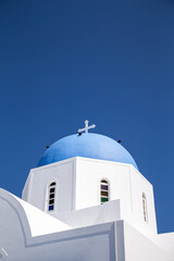 Fototapeta na wymiar Domes, steeples, bells and white buildings of Santorini, Greece 