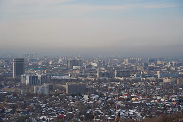 Fototapeta na wymiar Almaty, Kazakhstan - 01.31.2023 : Residential and commercial buildings of the city and smog over the entire territory.