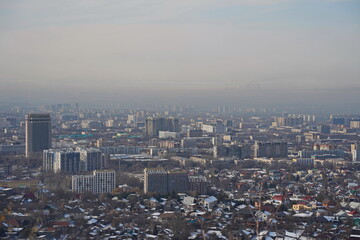 Almaty, Kazakhstan - 01.31.2023 : Residential and commercial buildings of the city and smog over the entire territory.