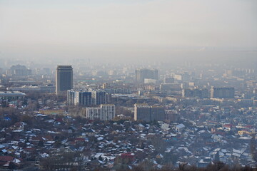 Almaty, Kazakhstan - 01.31.2023 : Residential and commercial buildings of the city and smog over the entire territory.