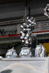 Three shiny metal teapots. Sale of metal teapots in the market.