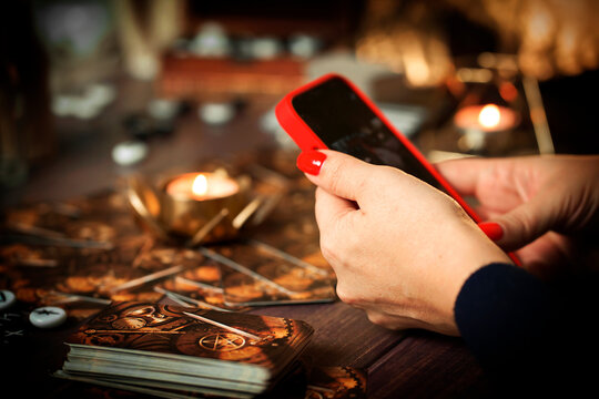 Future and online divination. A fortune teller does online fortune telling on photos from a smartphone.