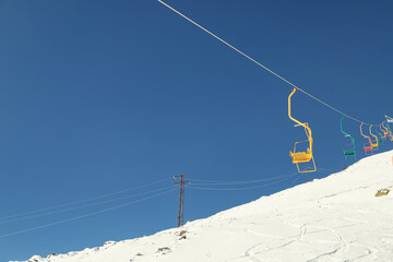 Chairlift climb to the top of a snowy slope