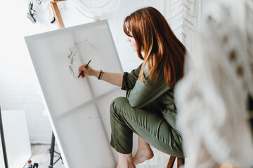 Young woman artist drawing painting in studio - 575852066