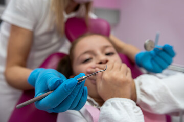 Naklejka premium dentist is going to perform tooth filling procedure on a frightened child in dental clinic.