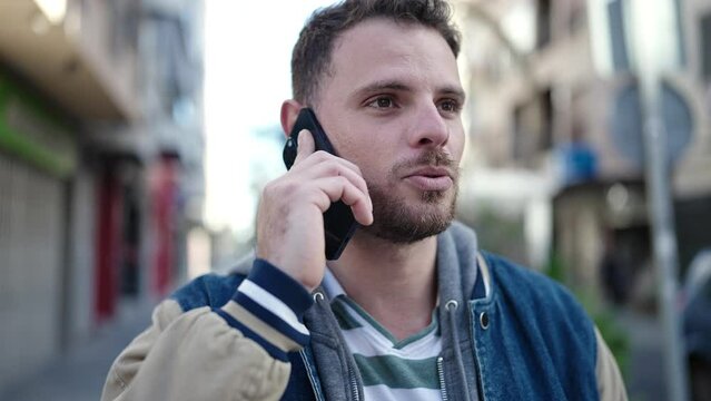 Young caucasian man speaking on the phone at street