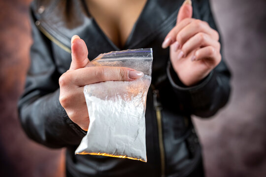 closeup of female drug dealer hold cocaine in plastic packet for sale