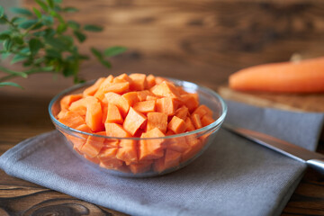 Diced carrots in a bowl, side view. Concept photo for a culinary website with a nice background.