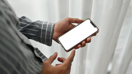 Closeup shot of man in shirt hands holding smartphone and pointing with finger. White screen for webpage or advertise text