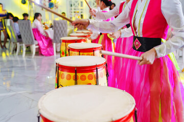 actors in national Korean costumes play drums. 