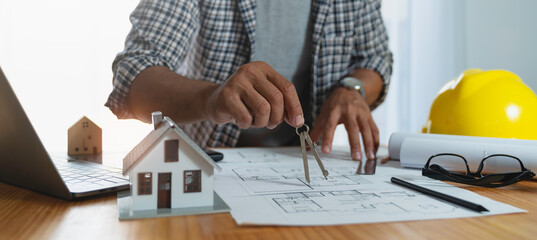Conceptual architect, young Asian engineer hand using compass drawing architect equipment On the...