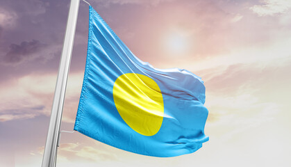 Waving Flag of Palau in Blue Sky. The symbol of the state on wavy cotton fabric.