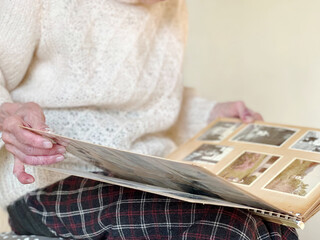 白黒セピア写真のアルバムを見る高齢女性の手 - obrazy, fototapety, plakaty