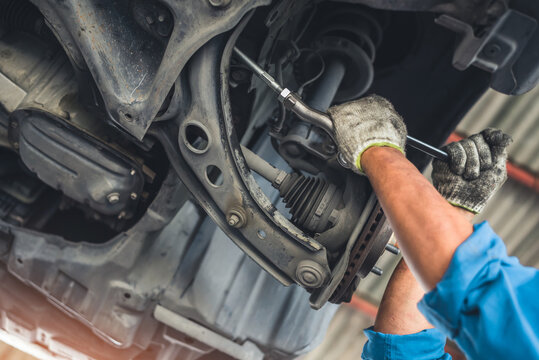 man changes a wheel hub with a wheel bearing in a car, Car disk brake pad replacement service by hand of mechanic man in car garage