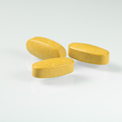 Three big yellow tablets with dietary supplements for seniors close-up