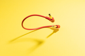 Red audio cable on the yellow background