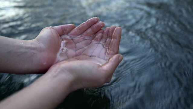 A female hand touching the river water