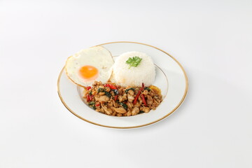 Rice topped with stir-fried chicken and holy basil, fried egg, and white plate.