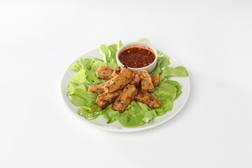 fried Vietnamese pork sausage or Thai northern pork sausage in white dish with green salad, Thai food.