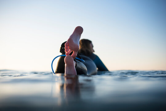 Woman lying on surfboard