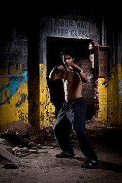 Male Fighter Standing In An Abandoned Building