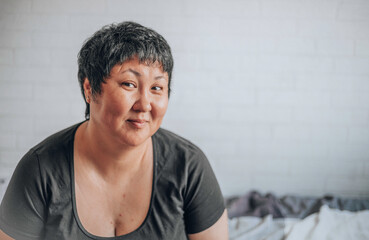 Asian woman of forty with a short haircut on a white background