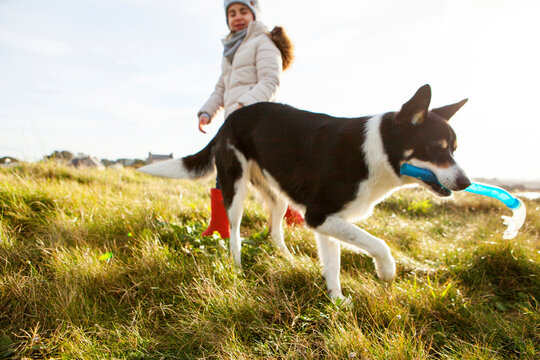 Girl and dog carrying snorkel in mouth